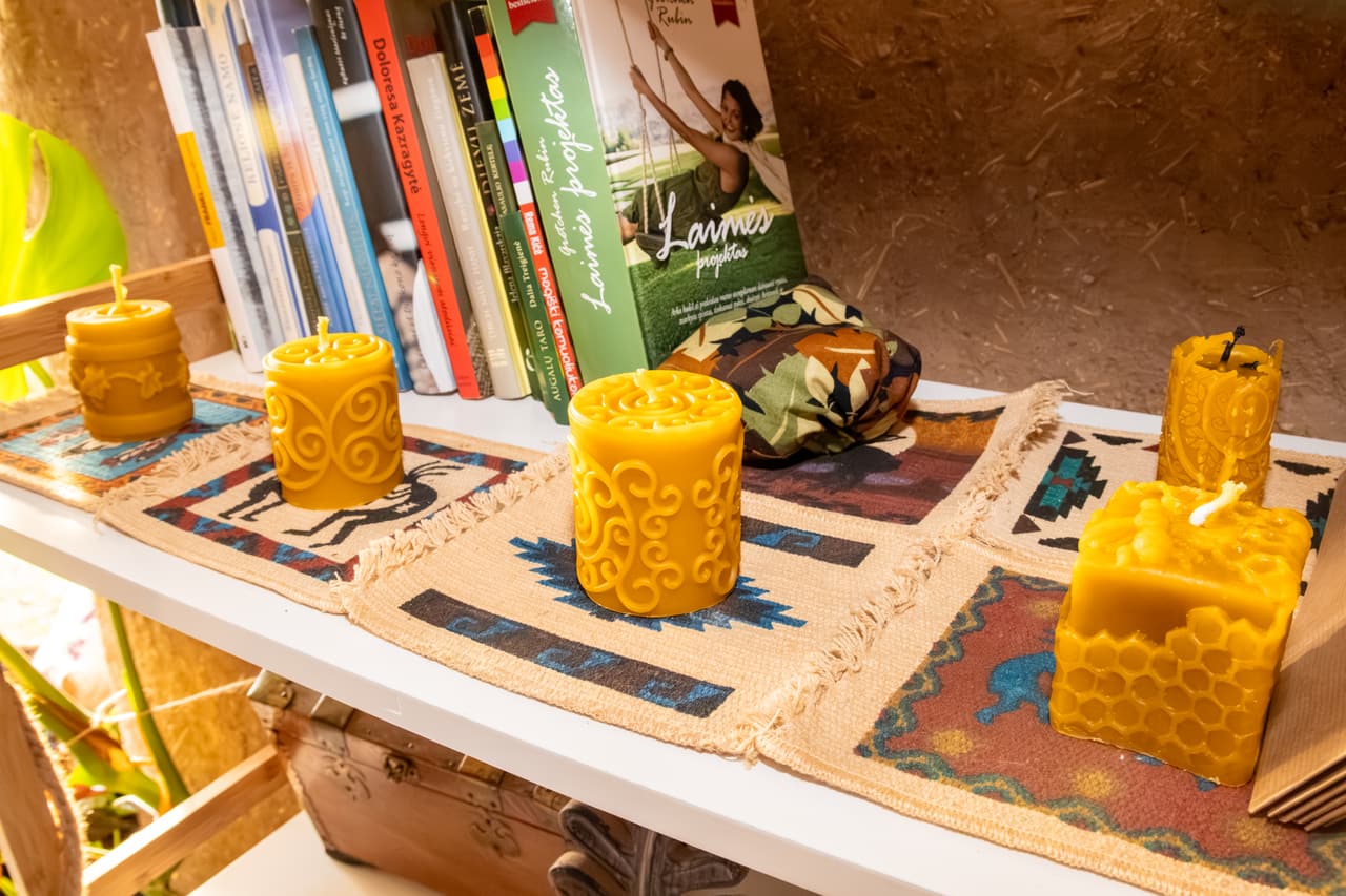 Beeswax candles on a shelf beside books